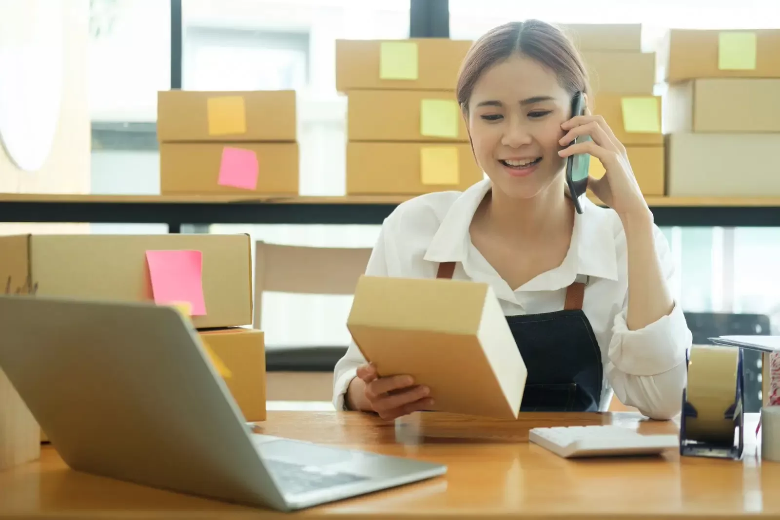 Woman holding box and talking on phone